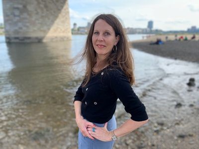 Autorin Petra Postert am Fluss unter einer Brücke.